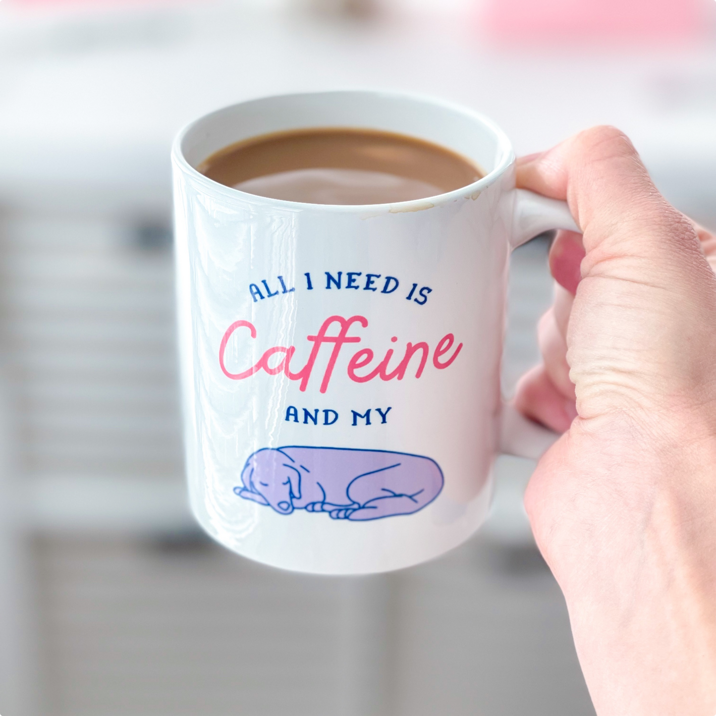 White mug that reads "All I need is caffeine and my dog"